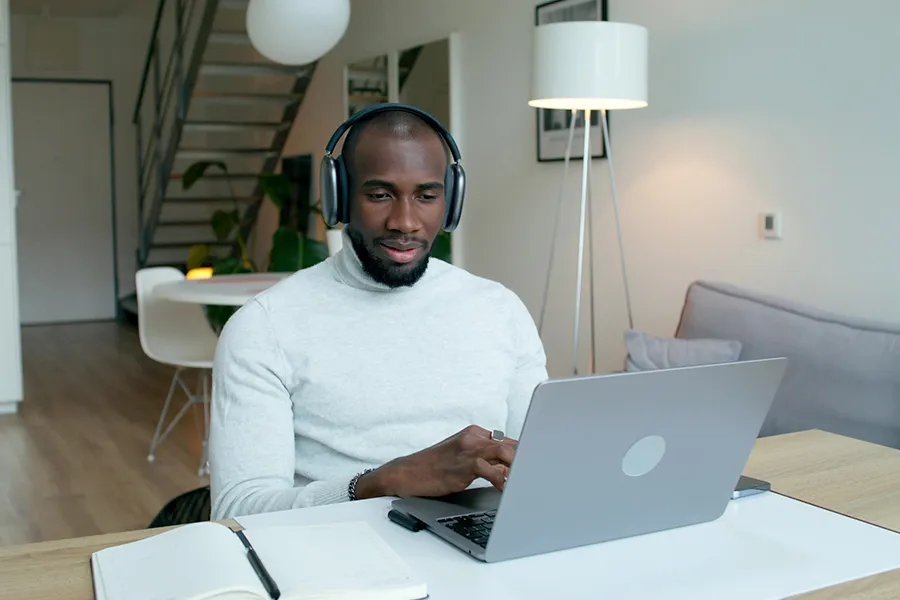 Ein Mann mit einem Headset, der zu Hause am Computer arbeitet